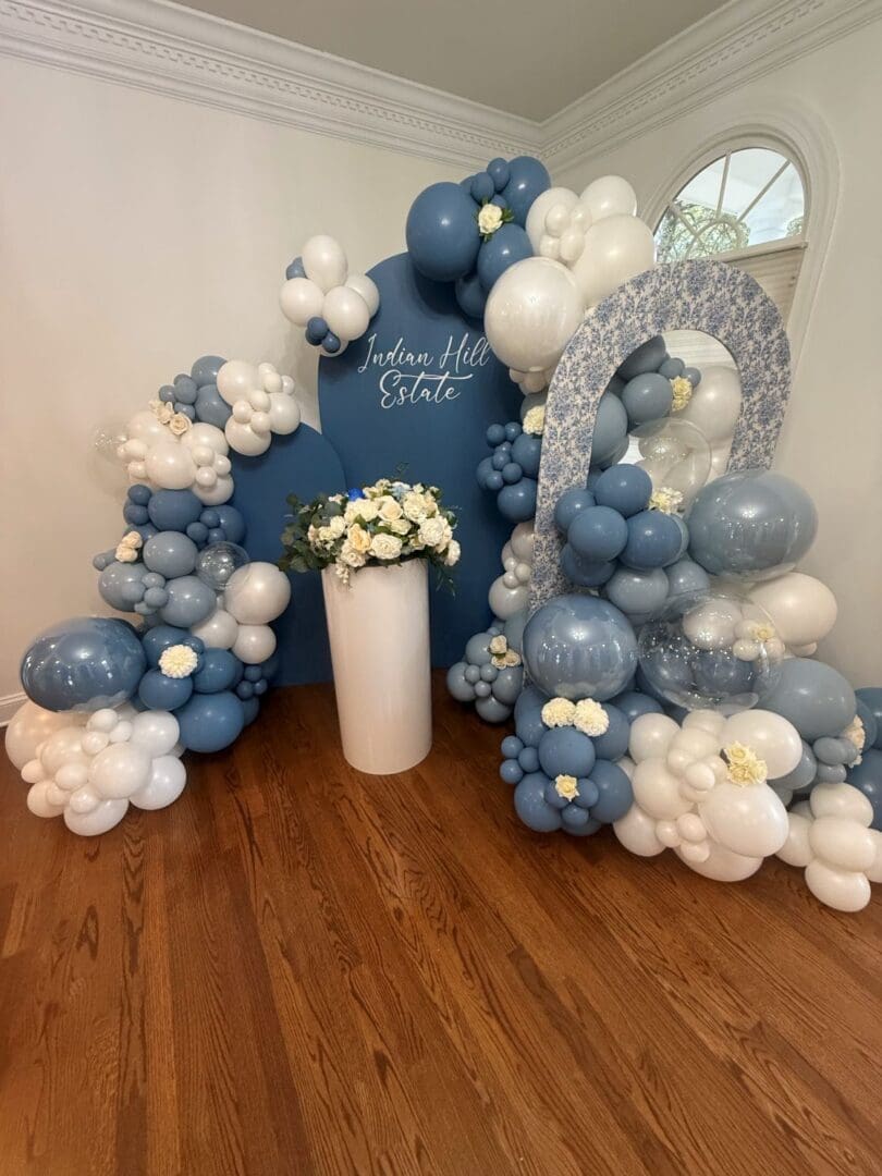 Blue and white balloon decoration with flowers.